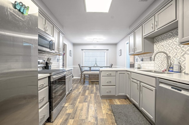 kitchen featuring dark hardwood / wood-style flooring, sink, gray cabinets, and stainless steel appliances