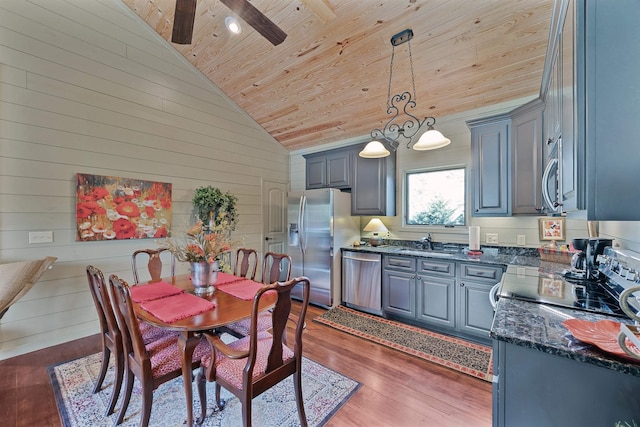 kitchen with dark wood-type flooring, sink, wood ceiling, appliances with stainless steel finishes, and pendant lighting