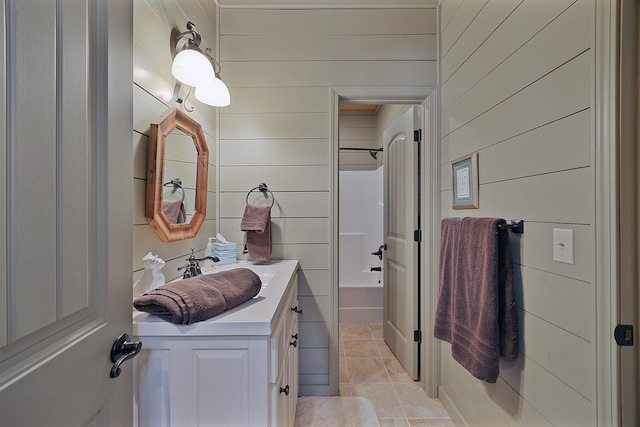 bathroom featuring shower / bath combination, vanity, tile patterned flooring, and wood walls