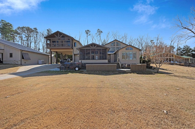 view of front of property with a front lawn, central AC unit, and a sunroom