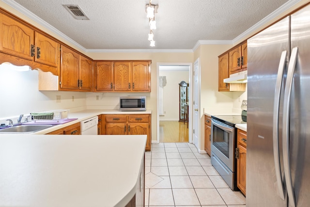 kitchen with light tile patterned flooring, sink, crown molding, a textured ceiling, and stainless steel appliances