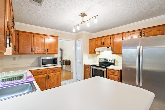 kitchen with sink, crown molding, light tile patterned floors, stainless steel appliances, and a textured ceiling