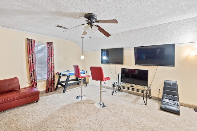 carpeted living room with ceiling fan and a textured ceiling