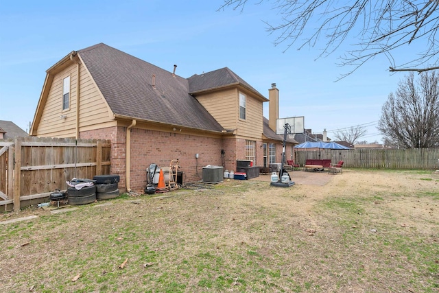 rear view of property featuring central AC, a patio, and a lawn