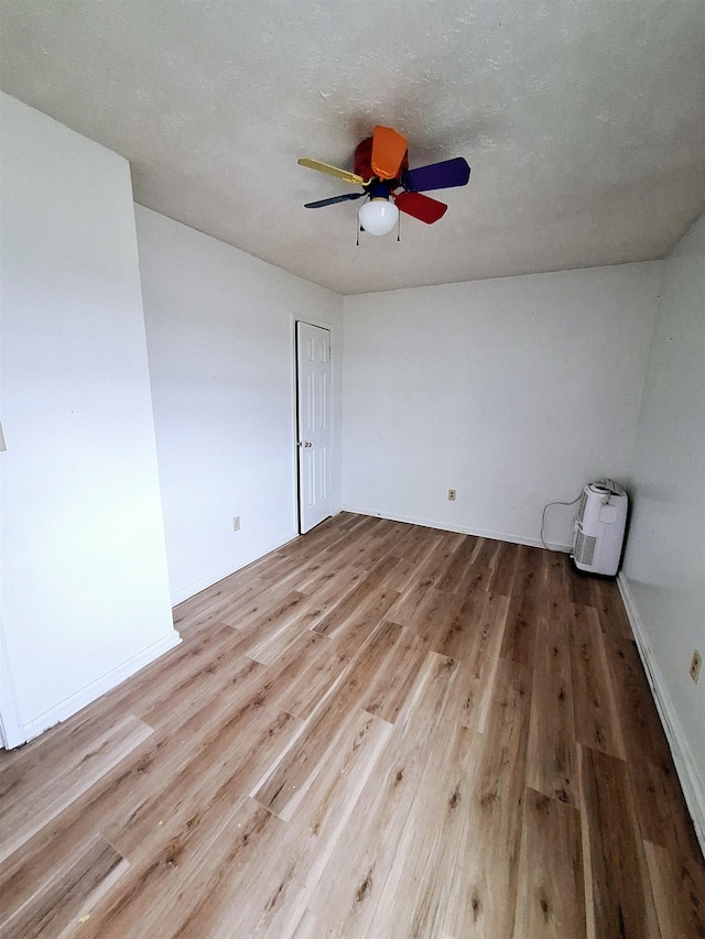 spare room with ceiling fan and light wood-type flooring