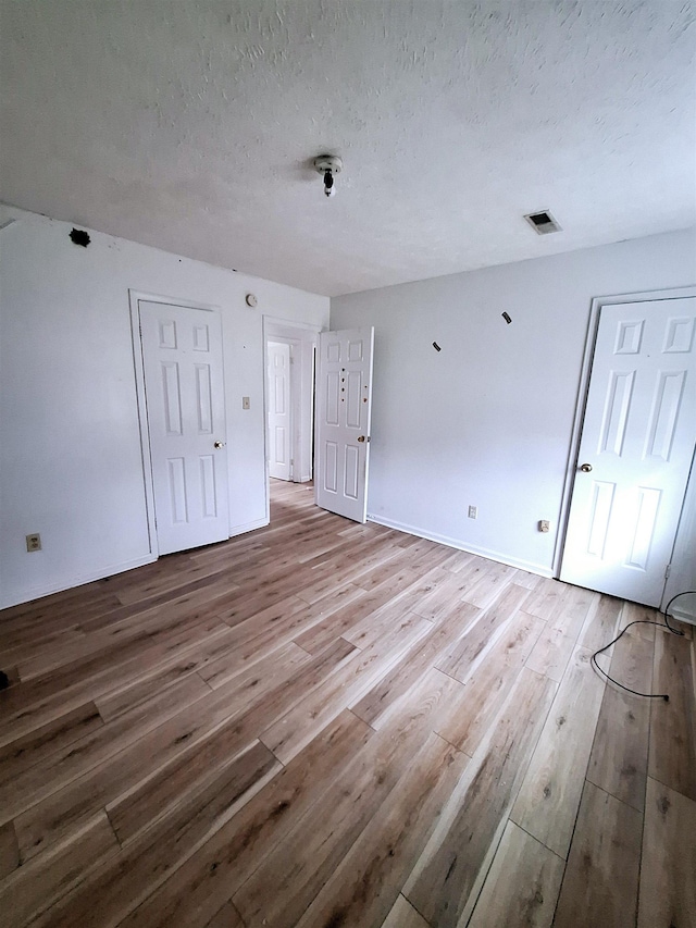 empty room featuring hardwood / wood-style floors and a textured ceiling