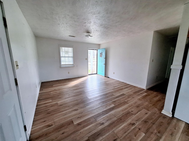 unfurnished room featuring a textured ceiling and light wood-type flooring