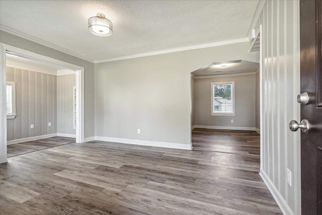 empty room with crown molding, hardwood / wood-style floors, and a textured ceiling