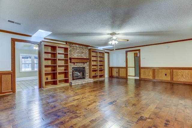 unfurnished living room featuring ceiling fan, hardwood / wood-style floors, and a textured ceiling