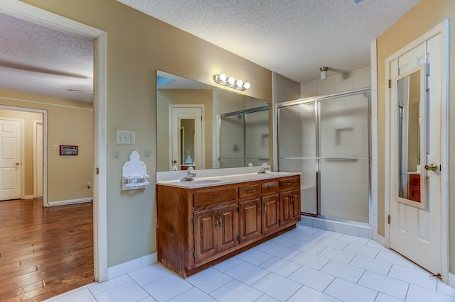 bathroom featuring vanity, a textured ceiling, and walk in shower