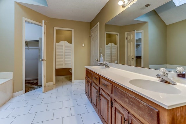 bathroom with vanity, tile patterned floors, and a bathtub