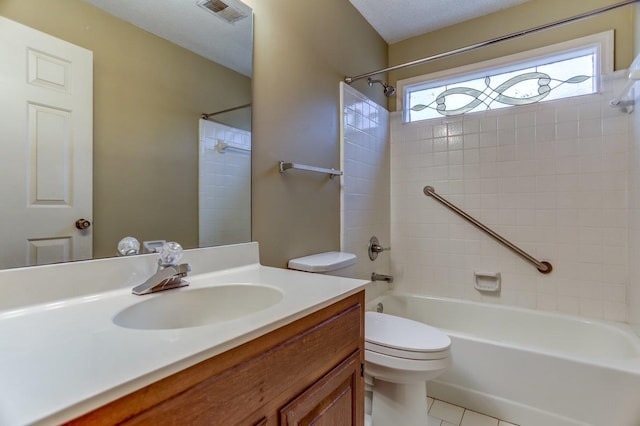 full bathroom with vanity, tile patterned flooring, tiled shower / bath combo, and toilet