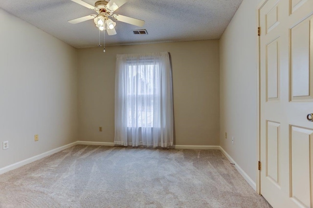 carpeted empty room featuring ceiling fan and a textured ceiling