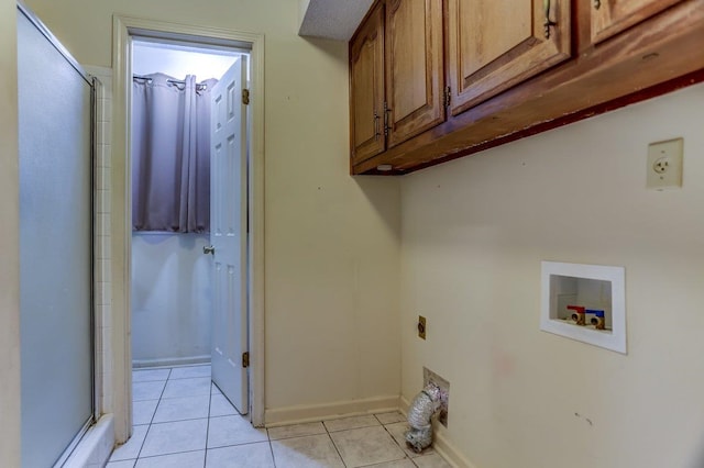 washroom featuring hookup for a washing machine, light tile patterned flooring, electric dryer hookup, and cabinets