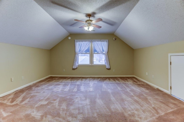 bonus room with ceiling fan, lofted ceiling, light carpet, and a textured ceiling