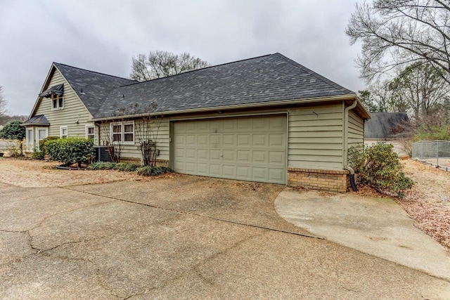 view of side of home with central AC and a garage