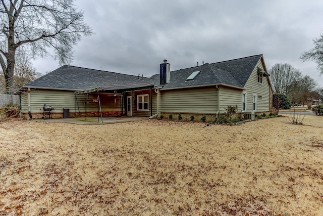 back of property with a yard and a patio area