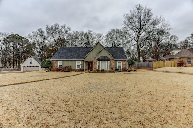 view of front of home with a garage, an outdoor structure, and a front yard