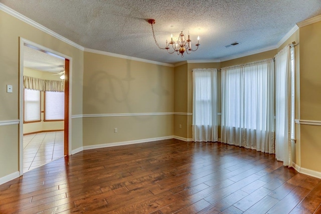 empty room with wood-type flooring, ornamental molding, a textured ceiling, and an inviting chandelier