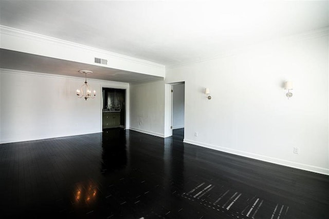 empty room with ornamental molding, dark hardwood / wood-style floors, and a chandelier