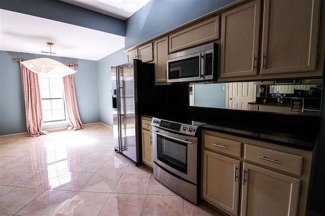 kitchen featuring decorative light fixtures, stainless steel appliances, and light tile patterned flooring