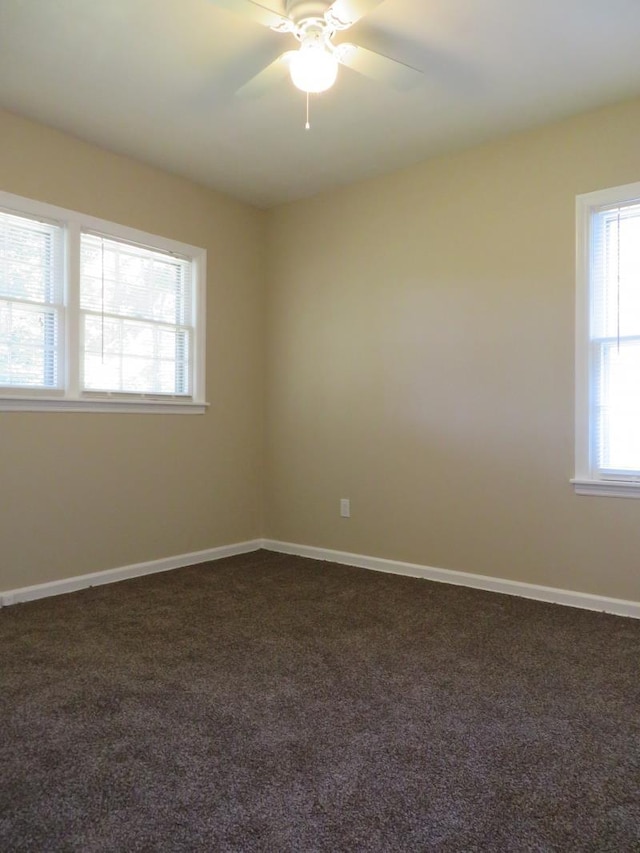 empty room featuring dark carpet and ceiling fan