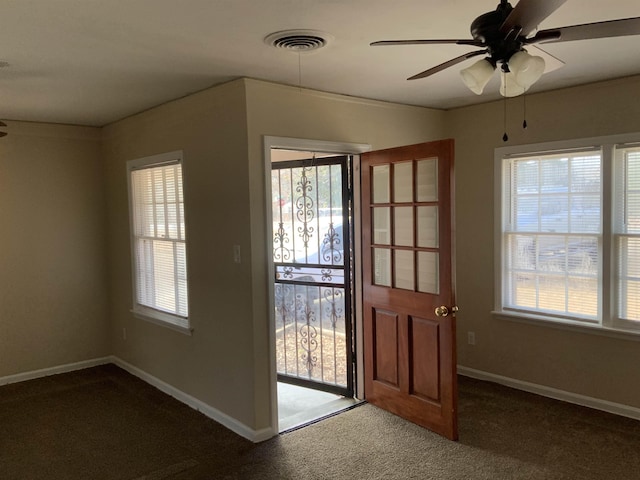 doorway with ceiling fan and dark colored carpet