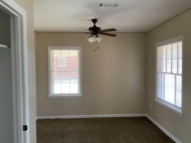 unfurnished room featuring dark carpet and ceiling fan