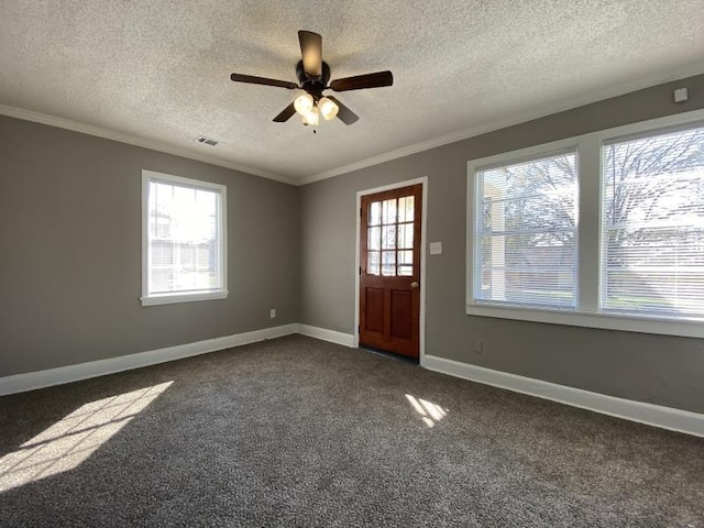 carpeted foyer entrance featuring crown molding, ceiling fan, and a textured ceiling