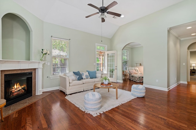 living room featuring dark hardwood / wood-style flooring, lofted ceiling, a tile fireplace, and ceiling fan