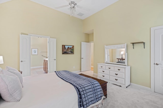 carpeted bedroom with a towering ceiling and ensuite bathroom