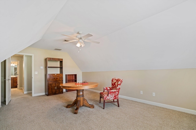 living area featuring vaulted ceiling, light colored carpet, and ceiling fan