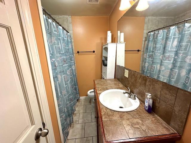 bathroom with tile patterned flooring, vanity, and toilet