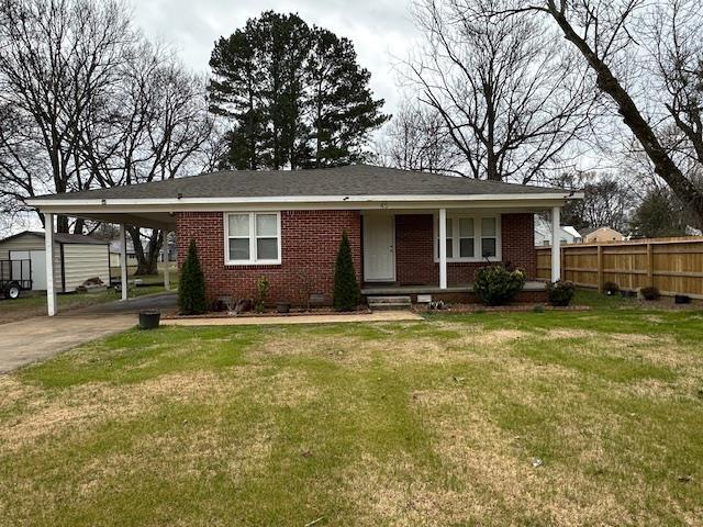 view of front facade with a carport and a front yard