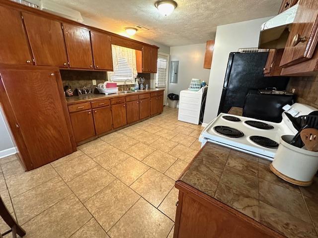 kitchen with washer / dryer, sink, a textured ceiling, white electric stove, and decorative backsplash