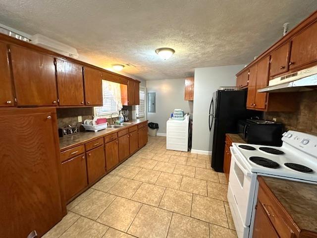 kitchen featuring electric panel, black appliances, a textured ceiling, light tile patterned flooring, and washer / clothes dryer