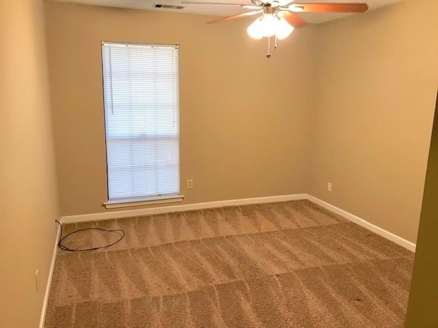 unfurnished room featuring ceiling fan, a healthy amount of sunlight, and carpet