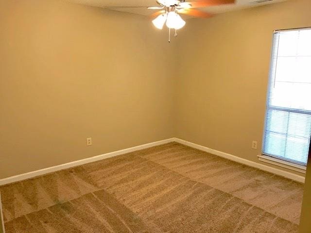 empty room with carpet floors, ceiling fan, and plenty of natural light