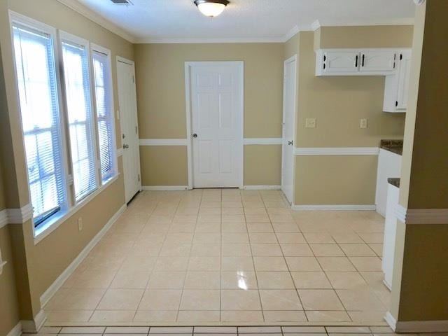 interior space featuring crown molding and light tile patterned floors