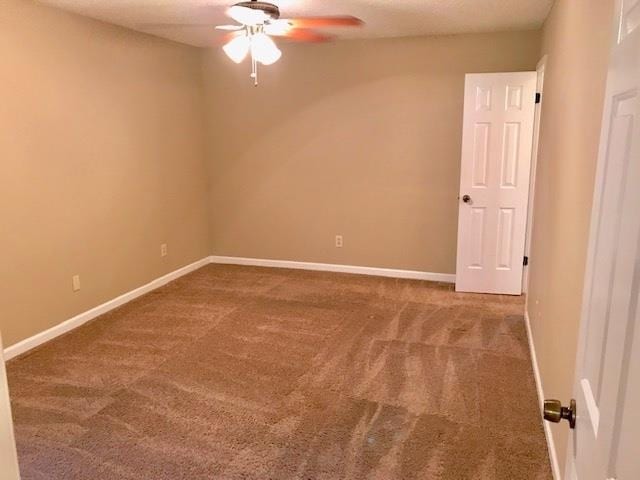 spare room with ceiling fan and carpet