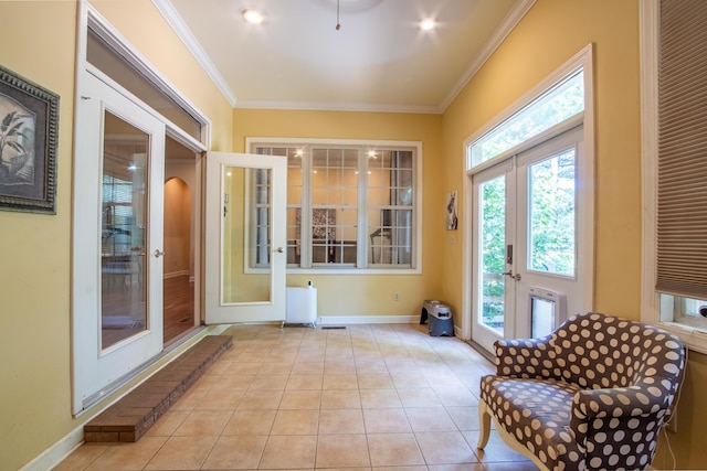 sitting room with french doors, ornamental molding, and light tile patterned floors