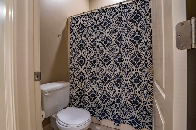 bathroom featuring walk in shower, toilet, and tile patterned flooring