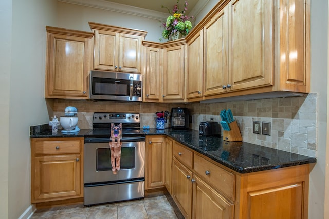 kitchen with crown molding, stainless steel appliances, dark stone counters, and backsplash