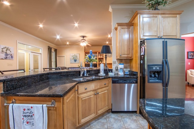 kitchen with sink, crown molding, light tile patterned floors, appliances with stainless steel finishes, and dark stone counters