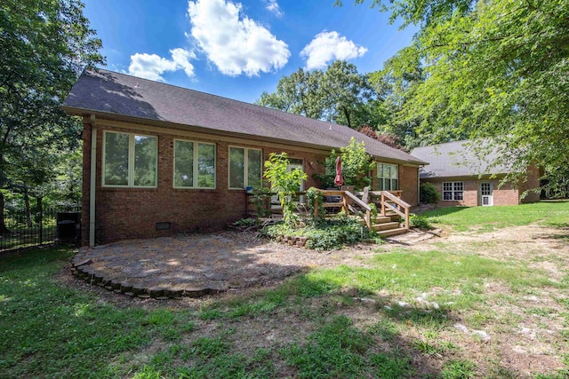 back of house featuring a wooden deck, a yard, and a patio