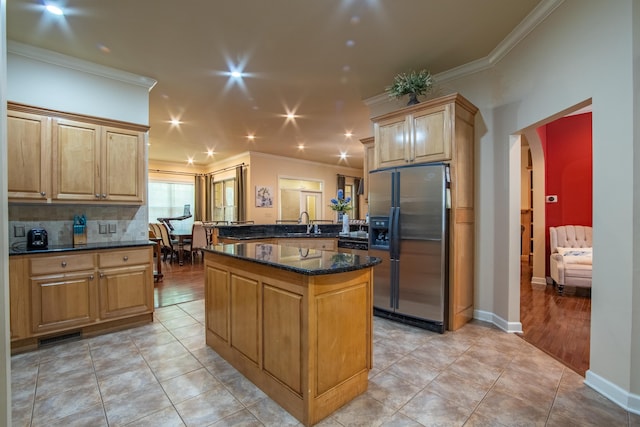 kitchen featuring dark stone countertops, crown molding, and stainless steel refrigerator with ice dispenser