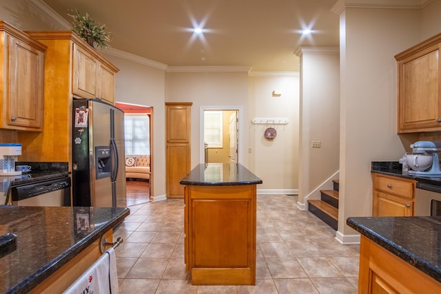 kitchen featuring a kitchen island, ornamental molding, dark stone counters, and appliances with stainless steel finishes