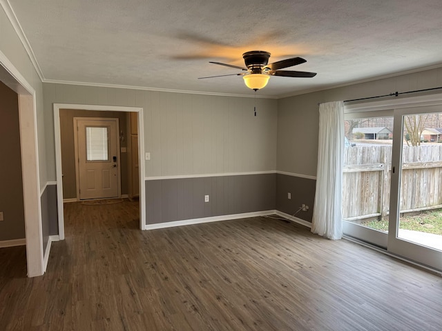 unfurnished room featuring dark hardwood / wood-style flooring, crown molding, and a textured ceiling