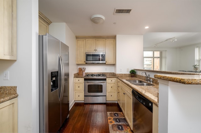 kitchen featuring sink, stainless steel appliances, light stone counters, dark hardwood / wood-style flooring, and kitchen peninsula