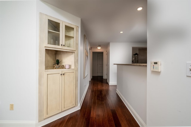 corridor with dark hardwood / wood-style flooring